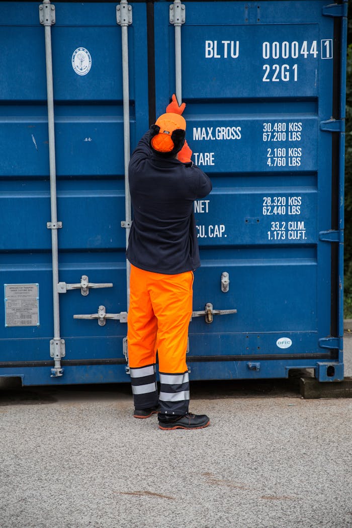 about-01 Industrial worker securing a shipping container outdoors, highlighting safety and logistics.